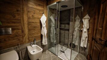 Une salle de bain moderne dotée d’une douche à parois de verre, d’un bidet et de lambris en bois.