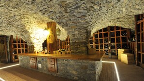 Eine Bar mit Steinwänden, Holzböden und einer zentralen Holzsäule.
