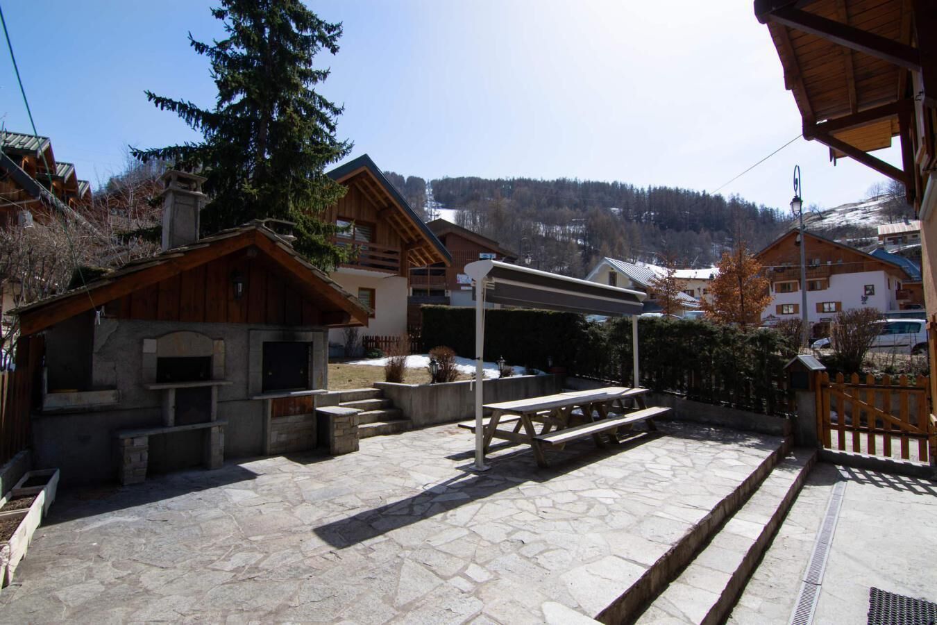 A stone patio with outdoor seating and a barbecue area.