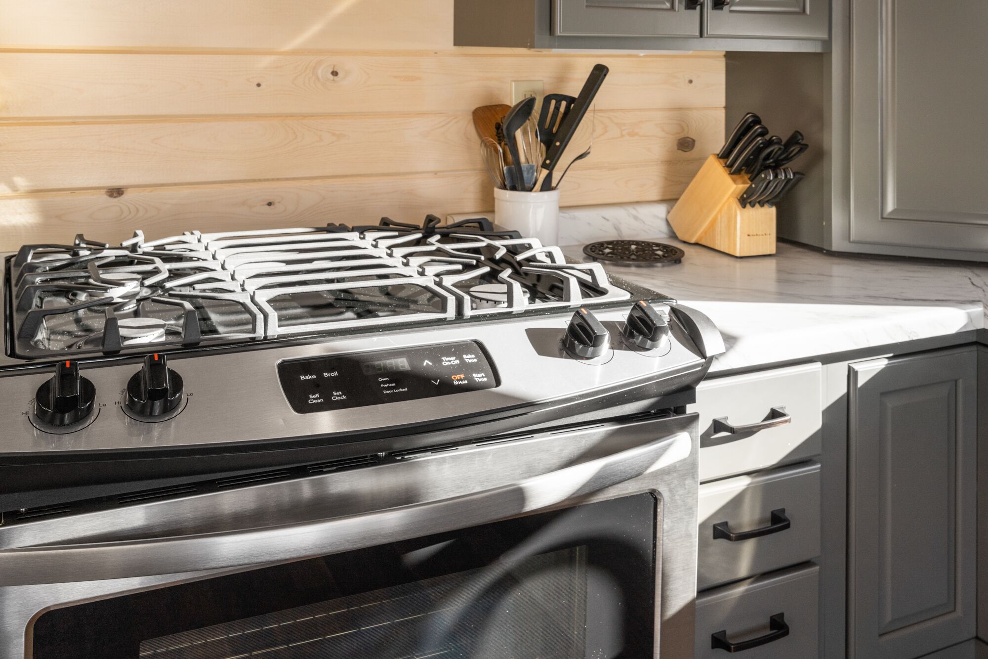 A stainless steel stove with four burners and a digital control panel.