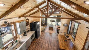 Un interior acogedor de cabaña con cocina, comedor y chimenea.