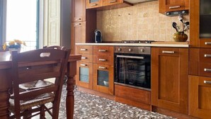 A kitchen with wooden cabinets, a countertop, and a built-in oven.