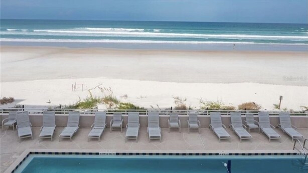 A poolside area with lounge chairs facing the ocean. - Beachside Sandcastle - Oceanfront, 1st-level Condo in Ponce Inlet (Ponce Inlet)