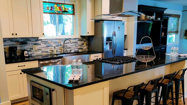 Una cocina moderna con una isla grande, electrodomésticos de acero inoxidable y piso de madera.