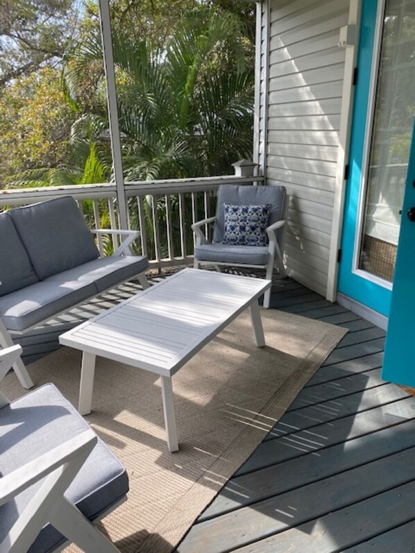 Relax in a serene outdoor seating area with a table and two chairs, surrounded by lush vegetation.