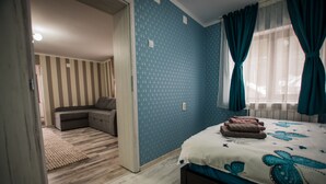 A bedroom with a bed, a sofa, and a window with curtains. - Stunning 5 Bed House in Campulung Moldovenesc (Campulung Moldovenesc)