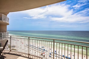 Un balcon avec vue sur la plage et l’océan.