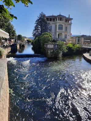 A canal with a bridge, surrounded by buildings and greenery.
