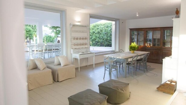 A spacious living area with a dining table, seating, and a view of the outdoors. - Villa Angela | Beautiful Villa with Pool in Puglia in Polignano a Mare, Italy (Polignano a Mare)