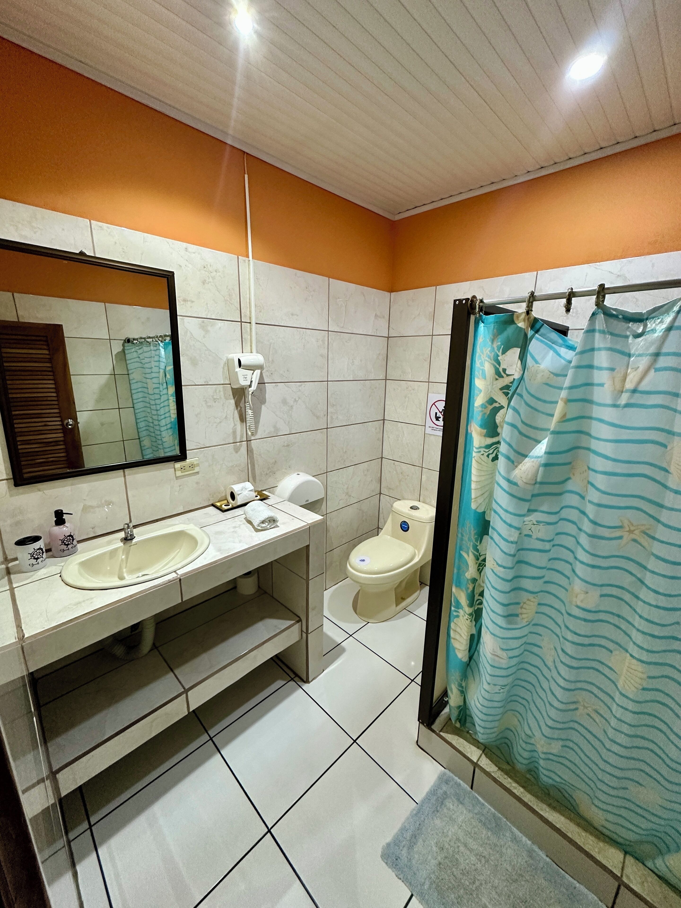A bathroom with two sinks, a toilet, and a shower curtain.
