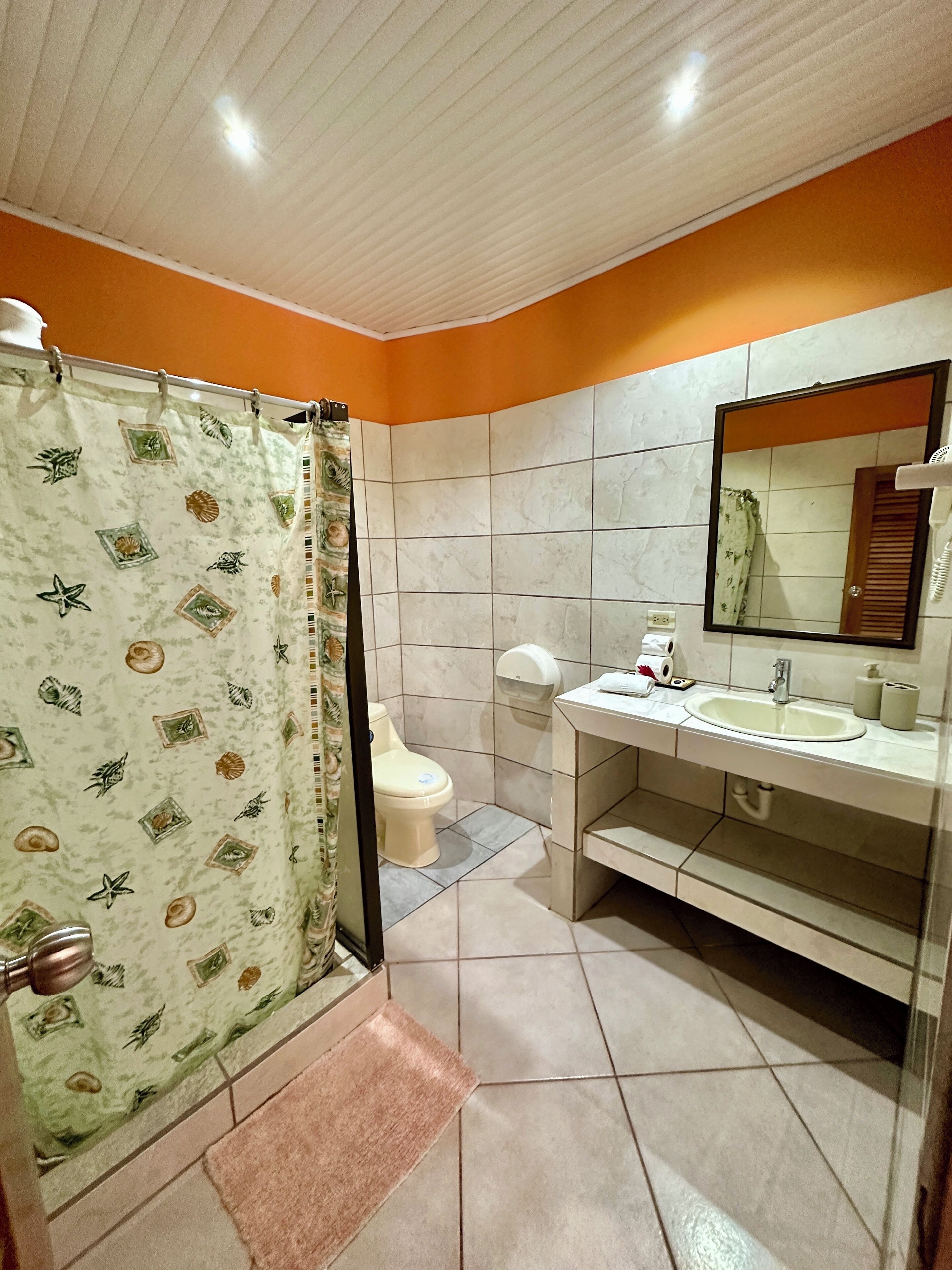 A bathroom with a toilet, sink, and shower curtain.