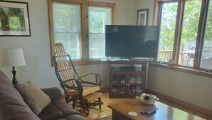A living room with a leather couch, wooden coffee table, and a television.