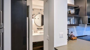 Une cuisine moderne avec des meubles de couleur sombre, un plan de travail en bois et un four encastré.