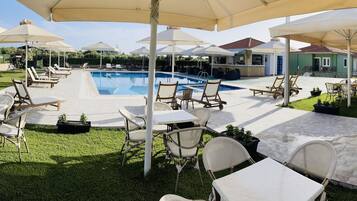 Een seizoensgebonden buitenzwembad, parasols voor strand/zwembad