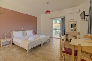 A hotel room with a bed, bedside table, desk, chair, and a balcony with a view. - Stomio Villague (Trifylia)