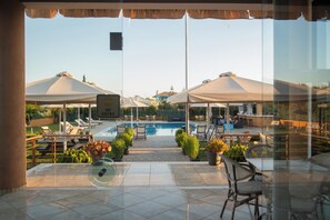 Una piscina al aire libre de temporada, sombrillas