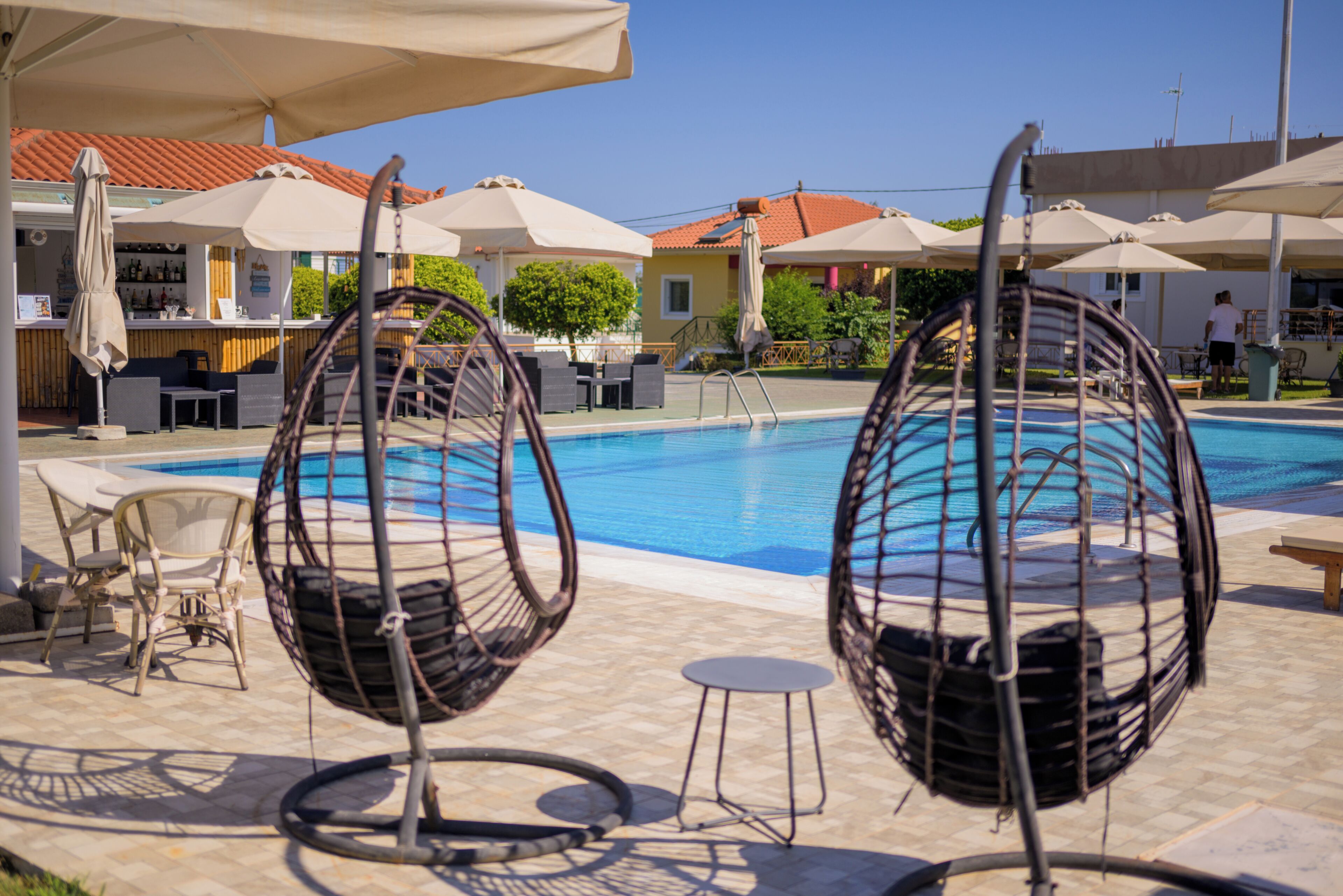 Una piscina al aire libre de temporada, sombrillas