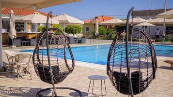 Una piscina al aire libre de temporada, sombrillas