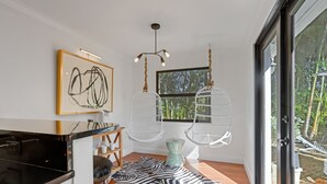 Una cocina moderna con encimera negra, alfombra estampada de cebra y una lámpara colgante.