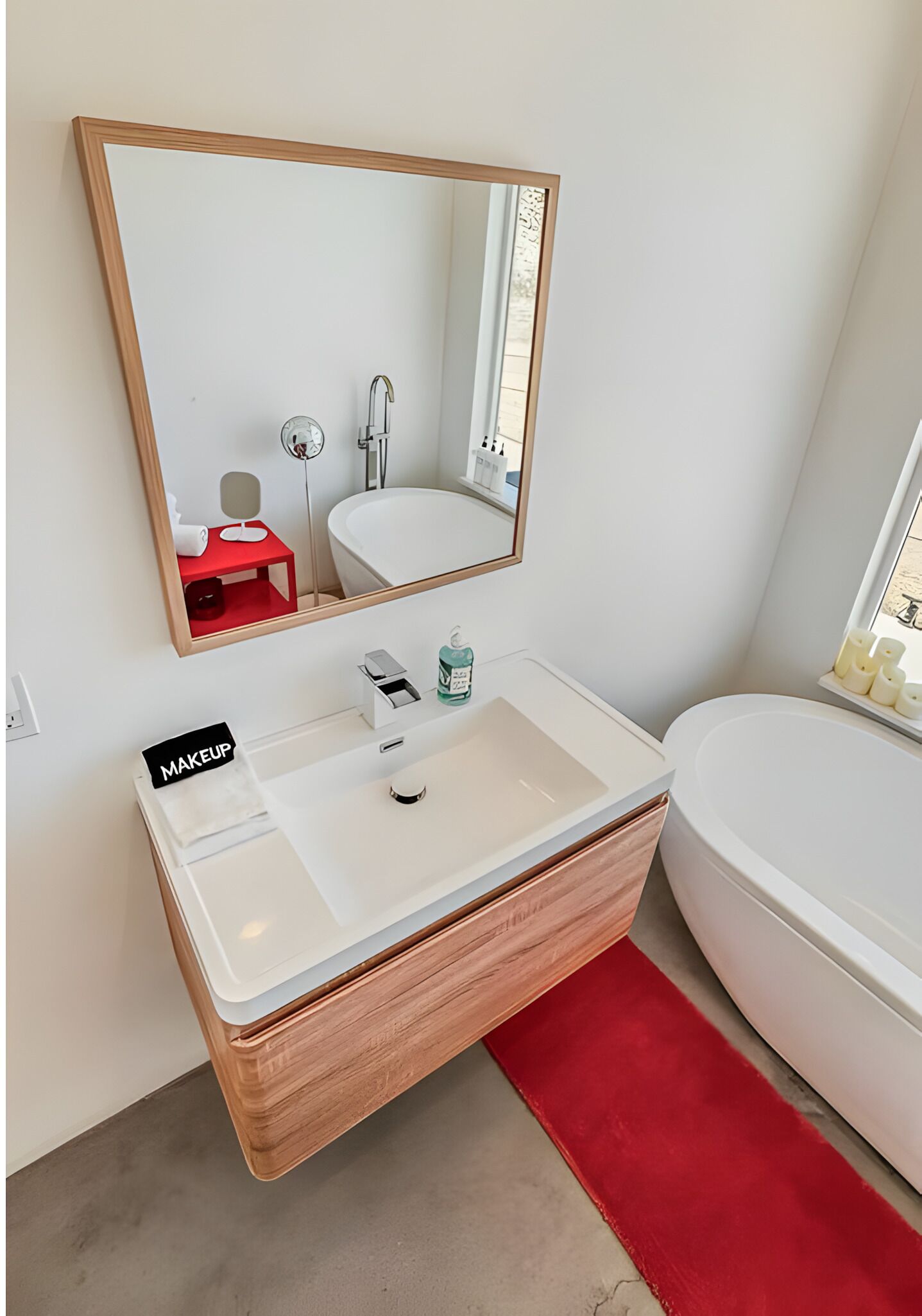 Un baño moderno con un lavabo blanco, un espejo y una bañera blanca.