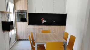 A compact kitchen with a central island, built-in oven, and a black backsplash.