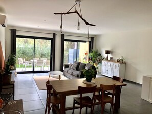 Une cuisine moderne avec une table à manger, des chaises et un luminaire suspendu.