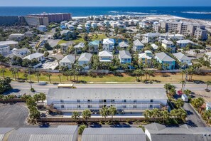 A coastal residential area with multiple-story houses, a beach, and a large parking lot.