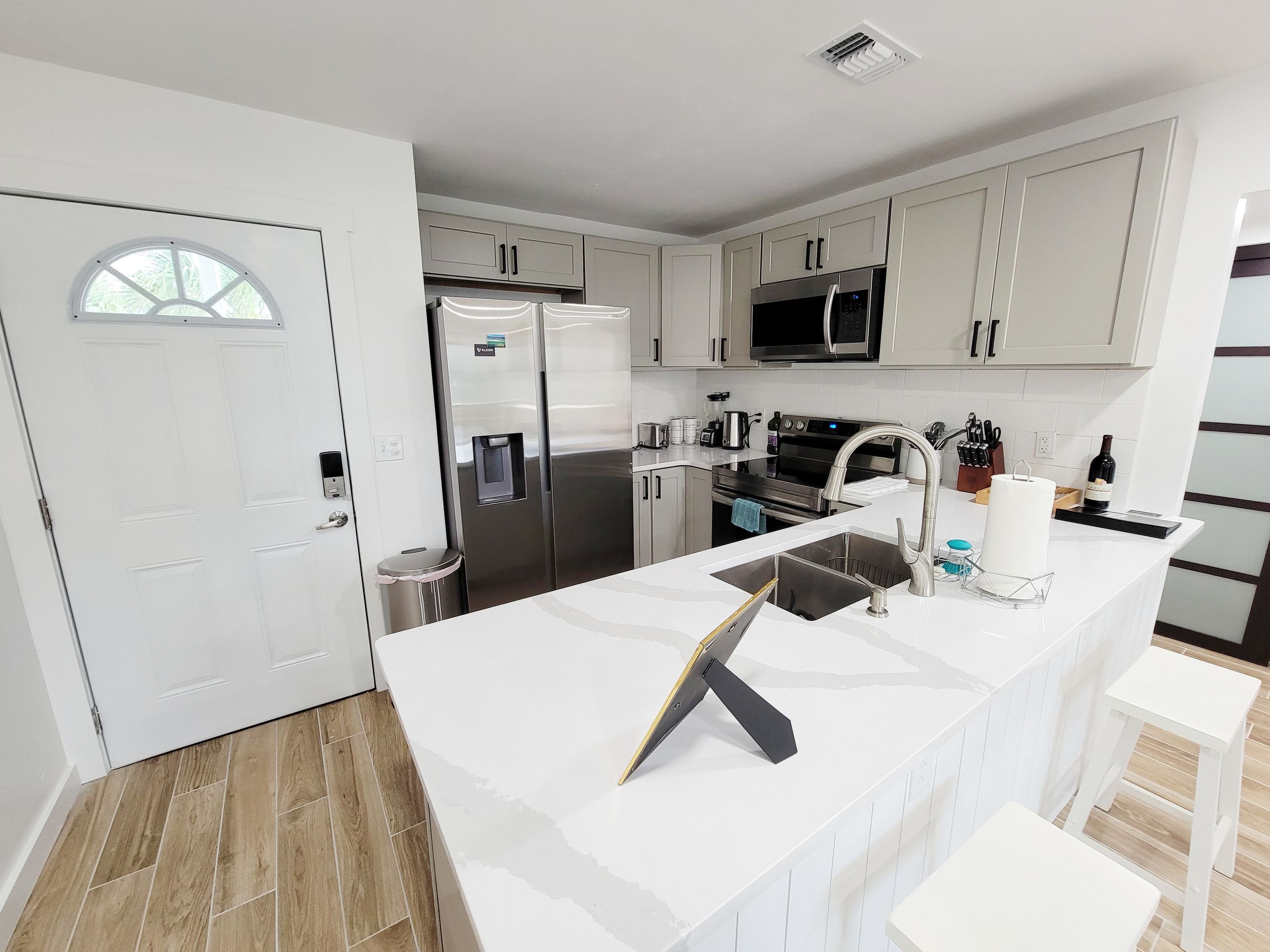 A modern kitchen with stainless steel appliances, a built-in microwave, and a large island with a sink.