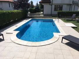 Una piscina al aire libre de temporada, sombrillas