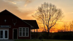 Un bâtiment rouge avec une enseigne indiquant « Windsong Adventures » et un décor en forme de crâne de cerf.