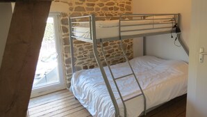 Ein Schlafzimmer mit Etagenbetten, Steinwänden und Holzboden.