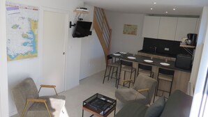 Ein modernes Apartment mit Essbereich, Küche und Wohnzimmer.