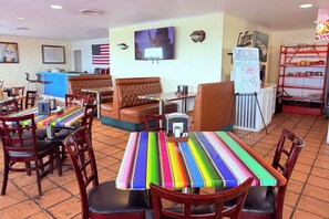 A restaurant interior with booths, tables, and a counter. - Champions Inn Del Rio Near Lake (Del Rio)