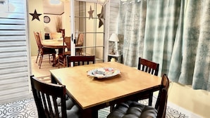 A dining area with a wooden table and chairs, a star decoration, and a lamp on a side table.
