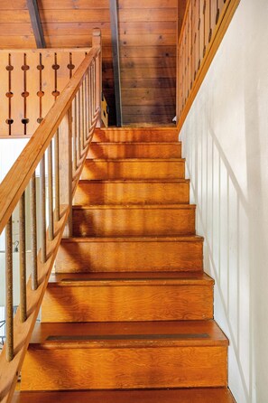 A wooden staircase with a handrail and a railing, leading to an upper floor. - Spacious Chalet with Game Loft & Pool Access (Arnold)