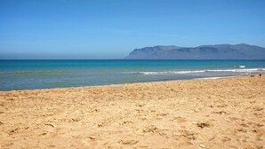 A beach with clear skies and distant mountains. - Curina Luxury Villa - design pool villa in Scopello (Castellammare del Golfo)