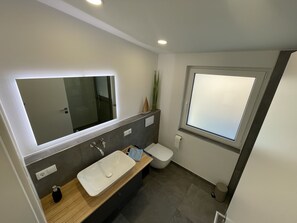 Een douche, een haardroger, zeep, toiletpapier
