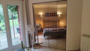 Ein Schlafzimmer mit einem Bett, Nachttischlampen und einem Ventilator.