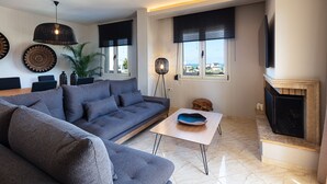 A modern living room with a grey sofa, a coffee table, and a fireplace.