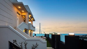 A modern building with a balcony overlooking a body of water.