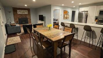 A modern kitchen with white cabinets, a stainless steel refrigerator, and a microwave.