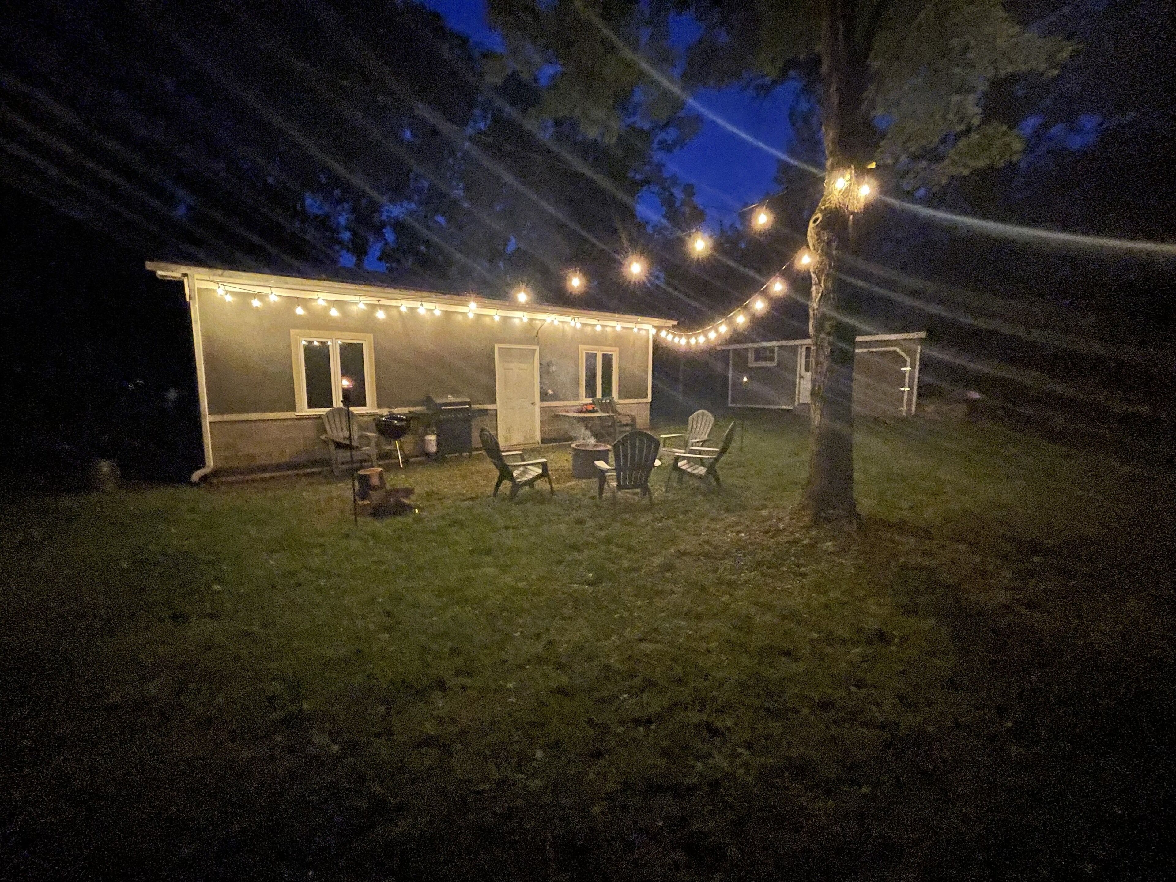 A house with a patio area featuring outdoor furniture and string lights.