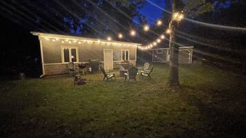 A house with a patio area featuring outdoor furniture and string lights.