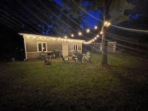 A house with a patio area featuring outdoor furniture and string lights.