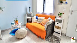 Ein Schlafzimmer mit einem Himmelsbett, einem kleinen Tisch mit Pflanze, einem Nachttisch und einer Kommode.