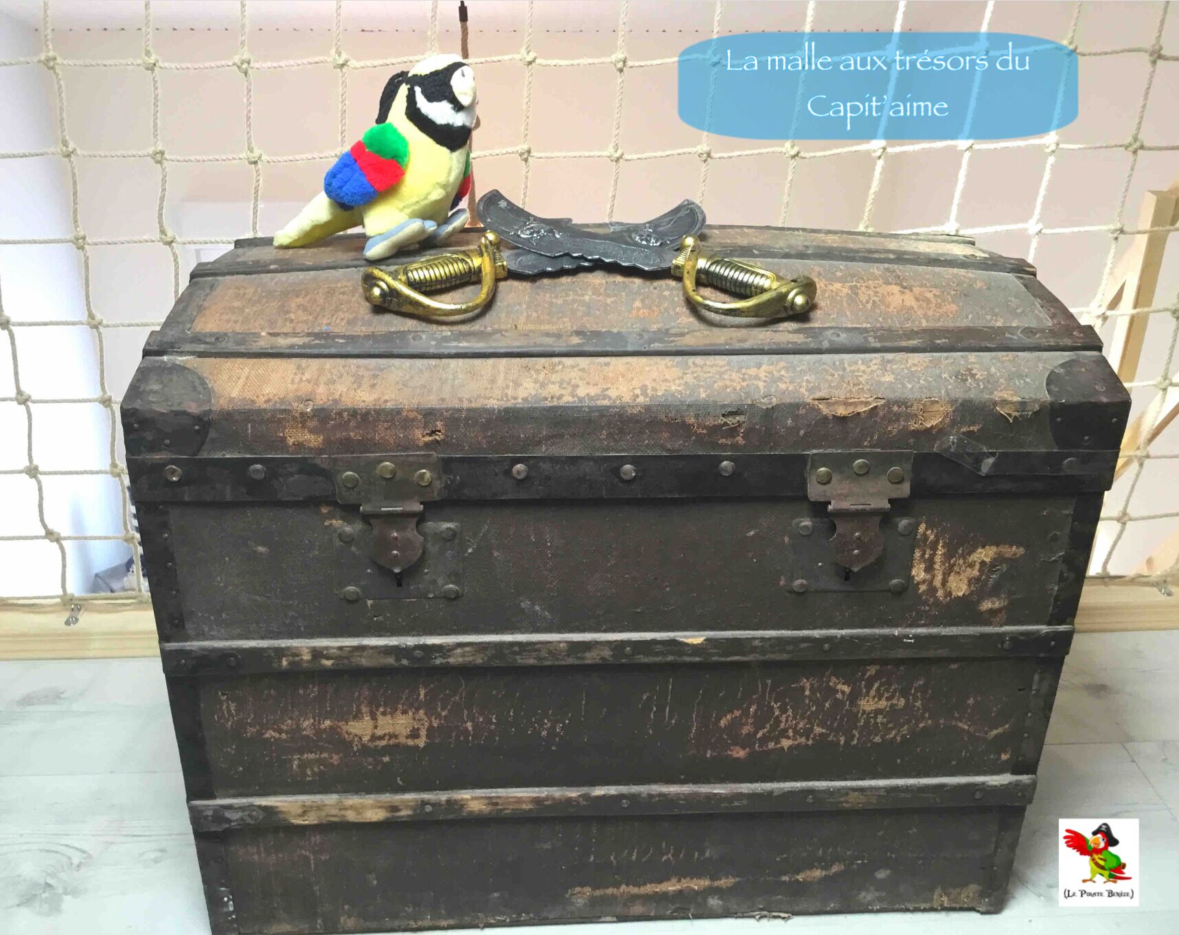 A vintage-style trunk with metal latches and brass handles, placed against a tiled wall.