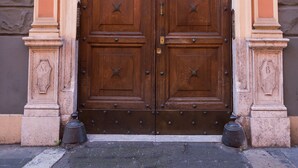 A double wooden door with decorative metal studs and a stone wall. - Rome Centro-Repubblica Apartment  (Roma)