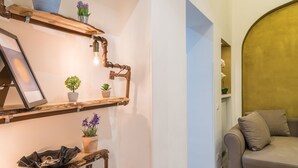 A modern living room with a wooden shelf unit holding decorative items and a framed picture. - Rome Centro-Repubblica Apartment  (Roma)