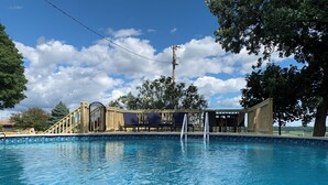 A swimming pool with lounge chairs and a wooden deck. - Jaggi Swiss Gasthaus  (Monticello)