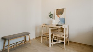A minimalist room with a wooden table, a bench, and a framed painting. - Bergen Beds - Studio Ground level (Bergen)